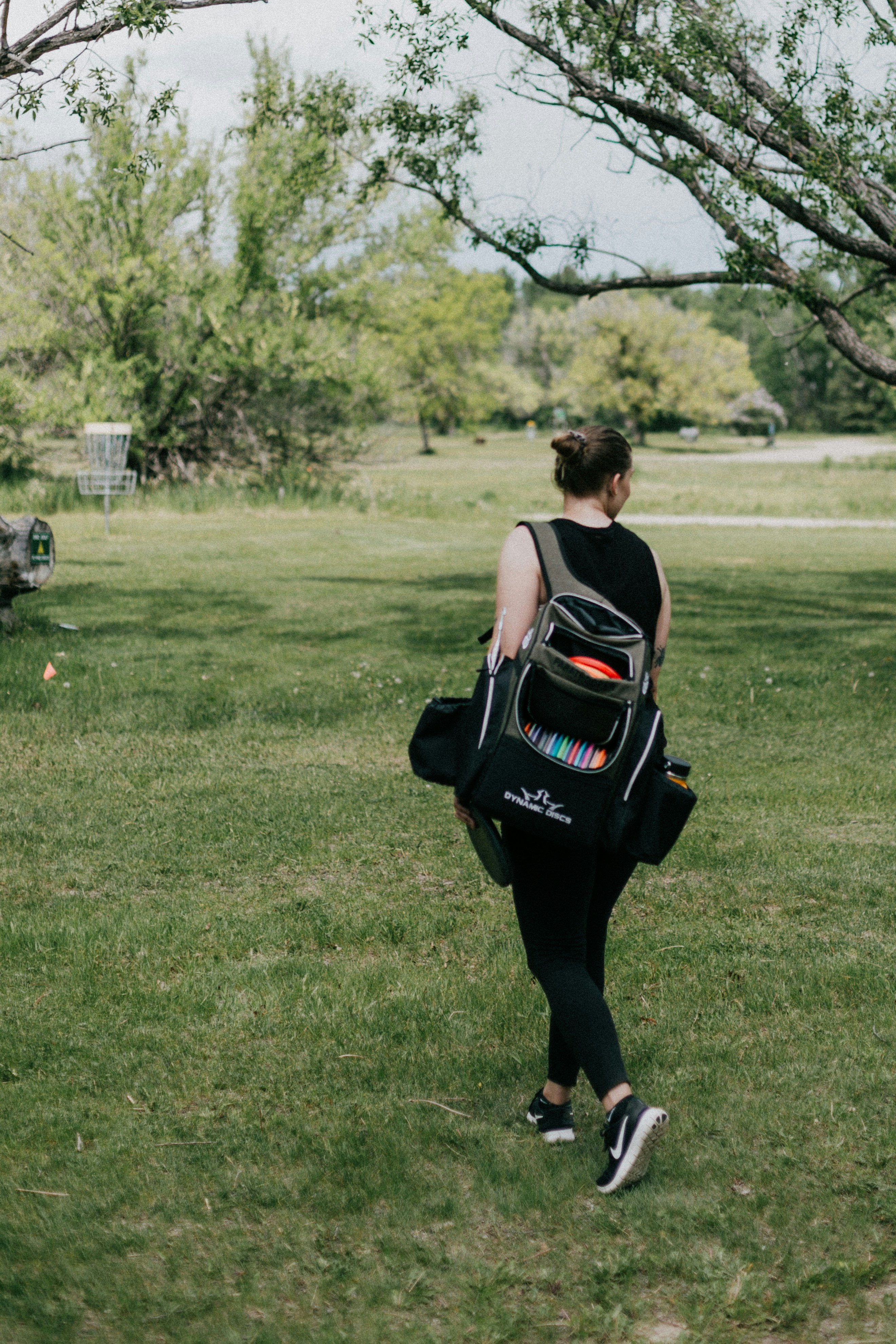 Frau mit praktischem Disc Golf Rucksack im Wald 2025
