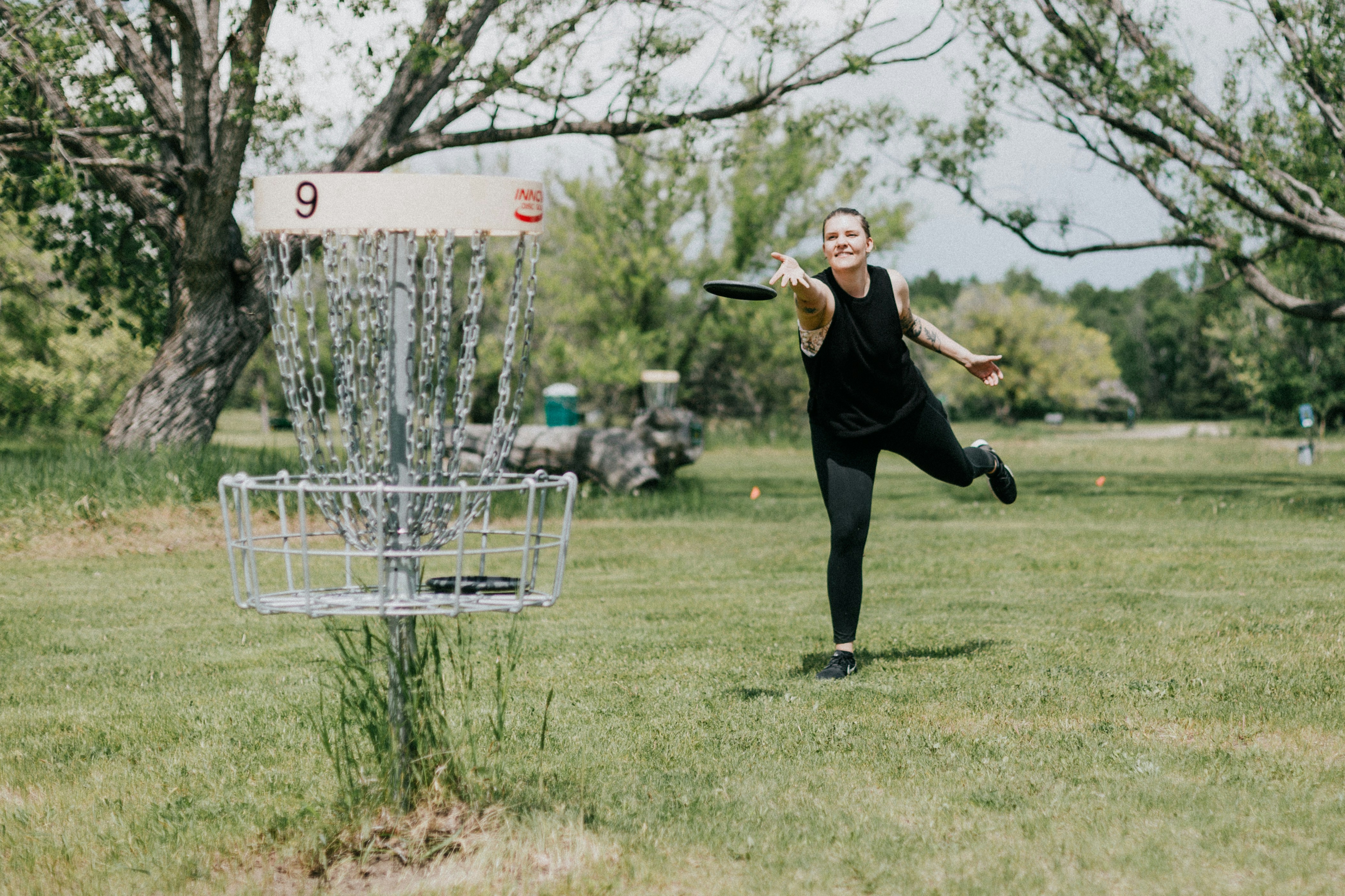 Disc Golf Spielerin wirf einen perfekten Korb in der Natur 2025